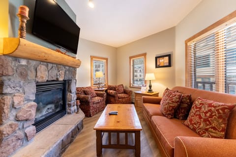Cozy up by the stone fireplace while watching your favorite shows in this warm, inviting living room.