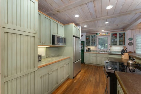 Kitchen with bar seating for 3, dishwasher, and standard drip-style coffeemaker.