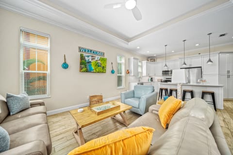 The living room is a cozy hub with plush seating, perfect for laughter-filled nights after a day at the beach.