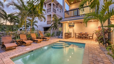 Twilight casts a warm glow over the pool and patio area, with subtle lighting highlighting the tranquil ambiance perfect for evening swims.