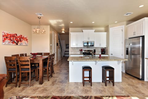 Kitchen View - The Kitchen and Dining Table can accommodate 10 adults and is stocked with pots, pans, baking sheets, mixing bowls, plates, bowls, cups, silverware, and a collection of cooking utensils.