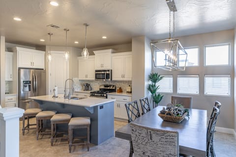 Kitchen And Dining Table - The Kitchen and Dining Table can accommodate 10 adults and is stocked with pots, pans, baking sheets, mixing bowls, plates, bowls, cups, silverware, and a collection of cooking utensils.