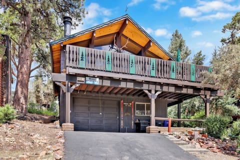 Welcoming cabin entry surrounded by towering pine trees, offering fresh mountain air and a peaceful forest setting—the perfect first impression for your Big Bear Lake getaway.