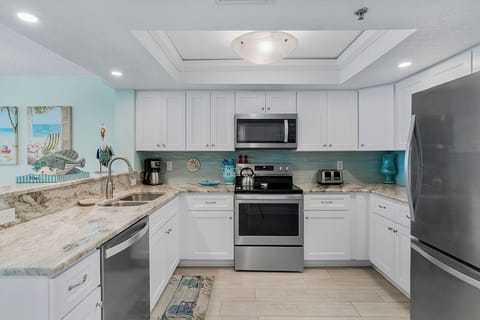 Cook your favorite meals in this fully-equipped kitchen with granite counters, stainless appliances, and bright coastal charm.