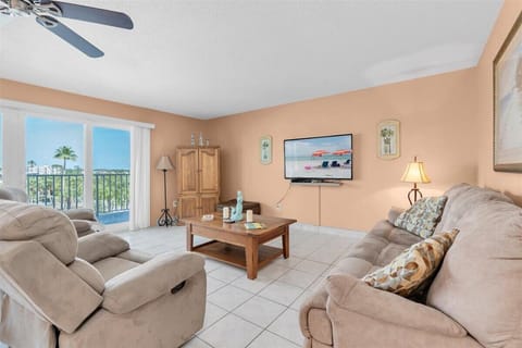 Sink into plush sofas and enjoy your favorite shows in this bright living room, where palm trees frame your balcony and tropical breezes drift through sliding glass doors.