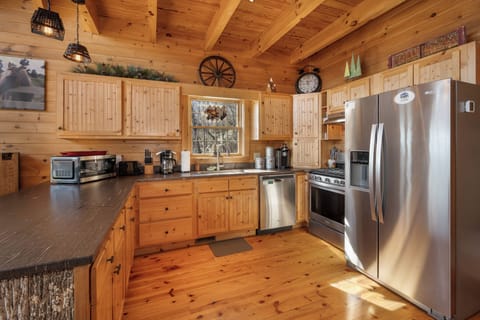Your rustic cabin kitchen awaits with full-size appliances and rich wood beams creating the perfect mountain cooking retreat.