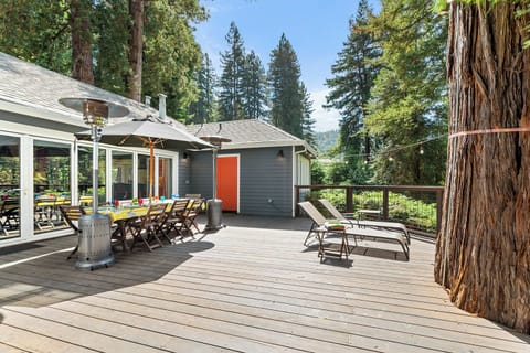 The expansive back deck boasts seating and dining areas, propane BBQ, outdoor heater, a hammock, and river views.