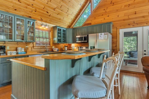 Open concept kitchen with bar stool for visiting during meal prep.