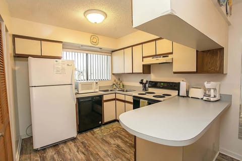 - Fully equipped kitchen with stove, microwave, refrigerator, and dishwasher
- Convenient breakfast bar doubles as a prep space or casual dining spot
- Warm lighting and wood flooring create a welcoming functional setup
