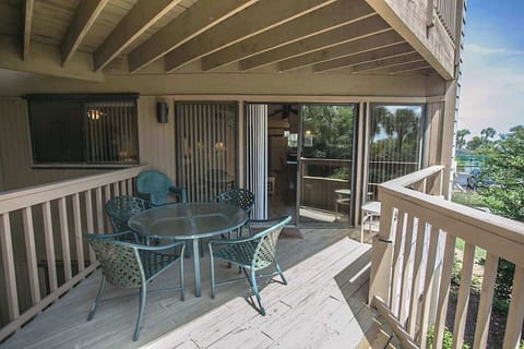 - Outdoor patio with round table and chairs for enjoying meals in the shade
- Sliding glass doors connect directly to the living space for easy access
- Surrounded by beautiful greenery providing a relaxing and private retreat