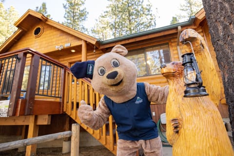 Welcoming cabin entry surrounded by towering pine trees, offering fresh mountain air and a peaceful forest setting—the perfect first impression for your Big Bear Lake getaway.