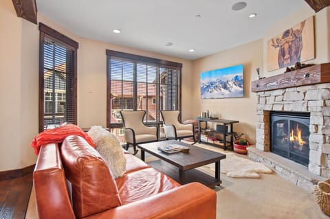 Sink into plush leather seating by your crackling stone fireplace, where mountain views and cozy alpine charm create your perfect retreat.