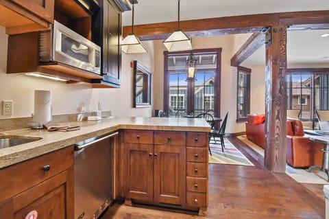 Your mountain retreat's fully-equipped kitchen features warm wood cabinetry and granite counters, perfect for preparing meals in this cozy space.