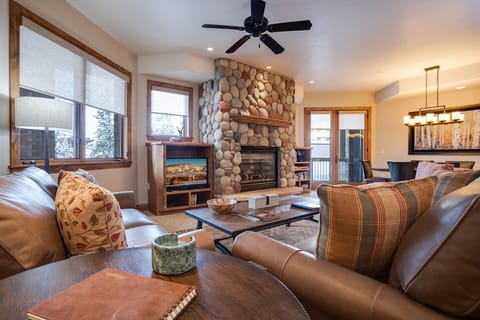 Cozy up in this inviting living space featuring a stunning stone fireplace and plush leather seating where you can unwind after your adventures.