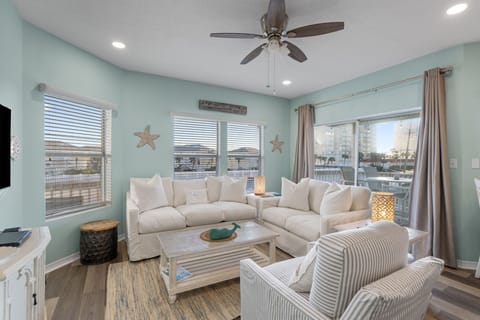 Sink into plush coastal comfort in your serene living space, where soft mint walls and beach-inspired décor create the perfect retreat.