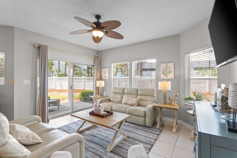 Sink into plush seating where natural light streams through sliding doors to your private patio. Ceiling fan keeps you cool while you unwind in this bright, airy retreat.