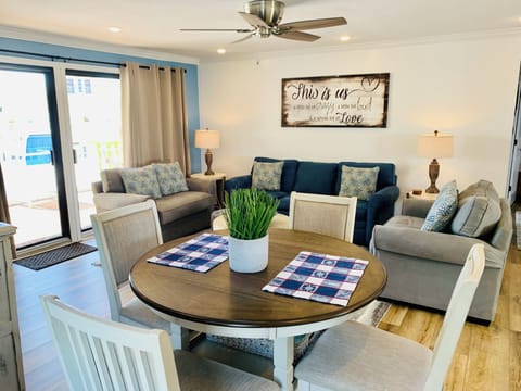 Unwind in your spacious living area where coastal blue tones meet warm wood accents, creating the perfect spot for family gatherings.