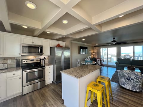 You'll love cooking in this bright kitchen with granite counters, stainless appliances, and ocean views from your open living space.
