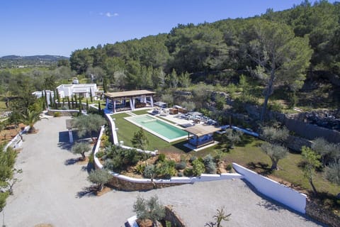 Aerial view of the beautiful luxury villa Can Ribes in Ibiza, Balearic Islands. You can appreciate the swimming pool and the garden, the terrace with a roof and the natural environment so well preserved.