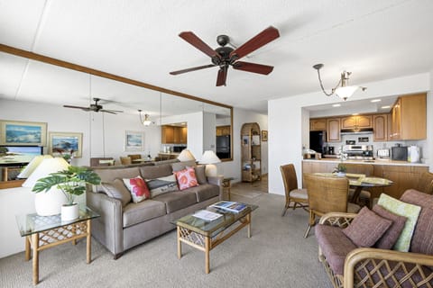 An open-plan living space with cozy seating, ceiling fans, and a welcoming kitchen with dining nook—your perfect home base for island getaways.