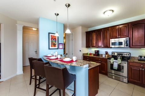 Luxurious and thoughtfully designed Kitchen of the condo in Orlando - Fully equipped with all necessary kitchen amenities - Plenty space to store goods - Availability of high chairs at breakfast bar with focus lamps