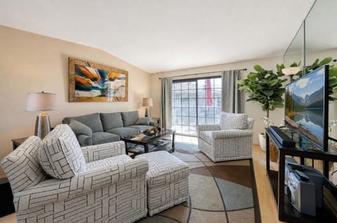 Sink into the plush sofa and unwind in your bright, welcoming living room. Large windows flood the space with natural light, while modern touches and greenery create your perfect home base.