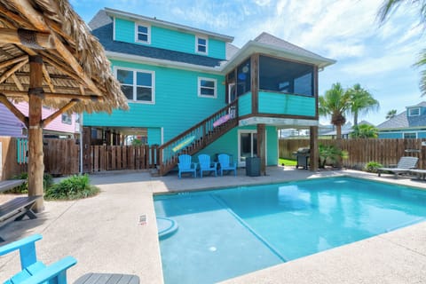 Dive into your private paradise with this stunning turquoise retreat featuring a sparkling pool and tropical tiki hut for ultimate relaxation.