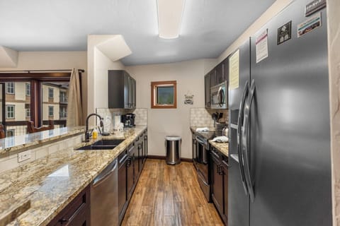 Full kitchen with granite countertops, stainless steel appliances, and breakfast bar seating.