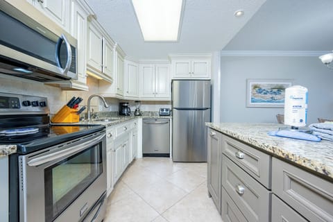 Prepare meals in the inviting kitchen featuring granite counters, stainless appliances, and elegant cabinetry