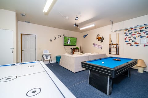Sports themed games room showing TV pool table, and air hockey table