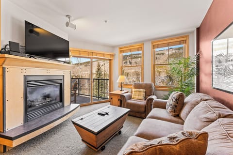 Cozy up in your mountain retreat with plush leather seating by the fireplace, scenic views through picture windows.