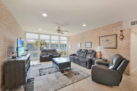 Sink into plush leather recliners in your stylish living room, where exposed brick walls and large windows create the perfect backdrop for relaxation.