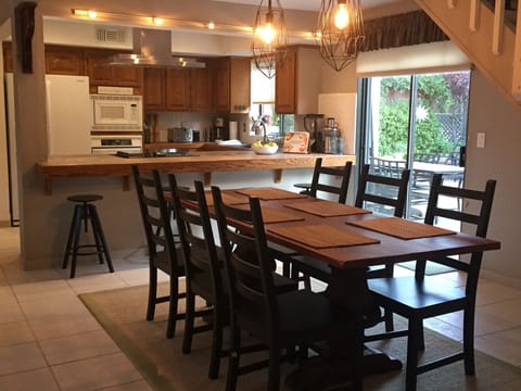 Farm style dining table for 6 and bar seating for 4 with sliding door to patio