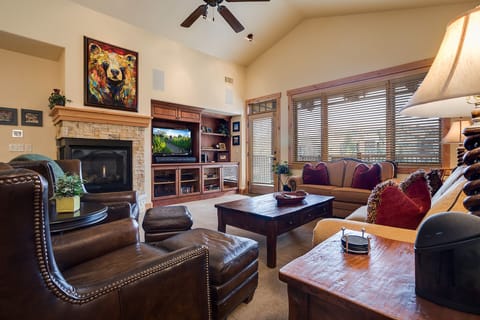 Sink into plush leather seating by your crackling fireplace, where vibrant art and warm wood create your perfect retreat.