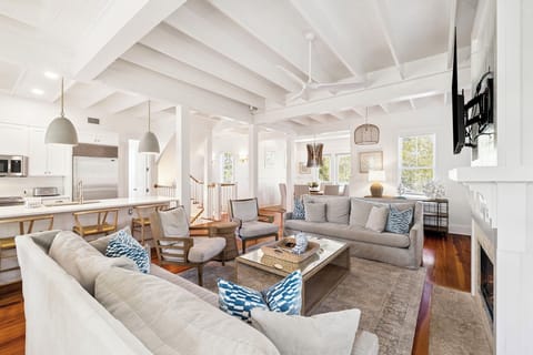 Gather with loved ones in this stunning open-concept living space featuring soaring vaulted ceilings and elegant coastal design.