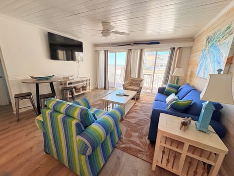 Sink into vibrant coastal comfort in your open living space, where colorful furnishings and ocean breezes create the perfect beach getaway retreat.