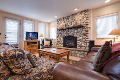 Sink into plush leather seating beside your crackling stone fireplace, where cozy evenings unfold with mountain views and warm ambiance.
