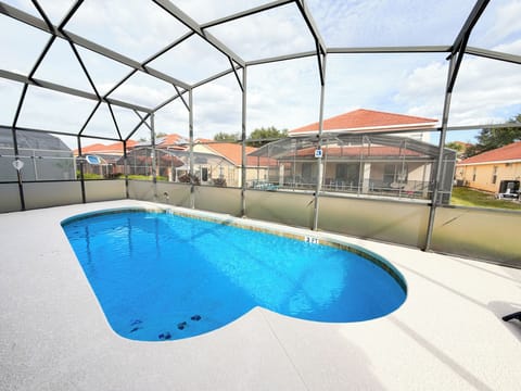 Private screened in pool with spacious sun deck at this Orlando vacation rental, offering a relaxing outdoor area for guests to enjoy Florida sunshine.