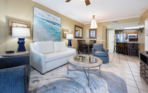 Stylish living area featuring a plush sofa with queen sleeper, elegant decor, and a view of the dining space and kitchen