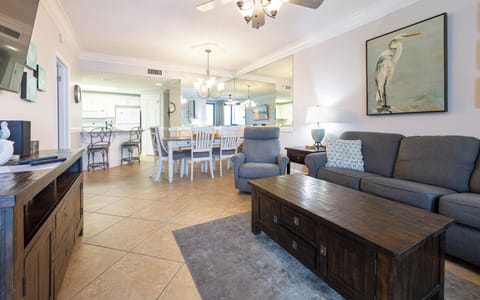 Relax in the comfortable living area, featuring a plush sofa, stylish decor, and a dining space for shared meals