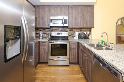 This kitchen features stainless appliances, granite countertops, and a stylish backsplash, perfect for meal preparation