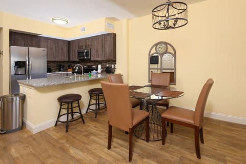 This modern kitchen features stainless appliances, granite countertops, and a cozy dining area with stylish seating