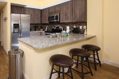 This kitchen features sleek stainless appliances, granite countertops, and a cozy breakfast bar for casual dining