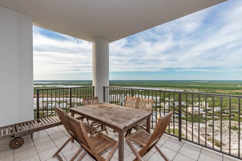 This balcony offers a stunning area view with a wooden dining set, perfect for enjoying outdoor meals