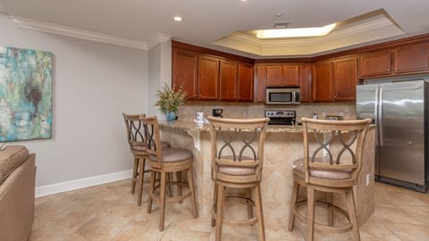 This kitchen features rich wood cabinetry, stainless appliances, and a cozy breakfast bar for a delightful cooking experience