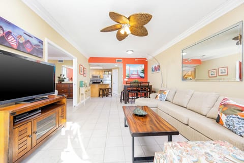 Unwind in the spacious living area with a large sofa, vibrant decor, and a seamless flow to the dining space