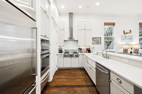 Your dream kitchen awaits with pristine white cabinets, marble countertops, and professional appliances ready for memorable meals.