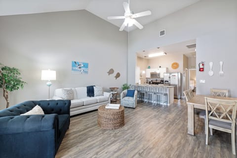 Relax in your bright open-concept living space where coastal colors and comfortable seating create the perfect home base for your getaway.