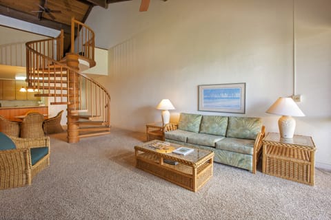 Unwind in your spacious living room with coastal-inspired decor, plush seating, and a charming spiral staircase leading to your private loft retreat above.