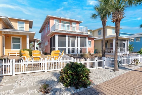 Colorful beach houses with charming white picket fences and swaying palm trees create the perfect coastal getaway atmosphere.